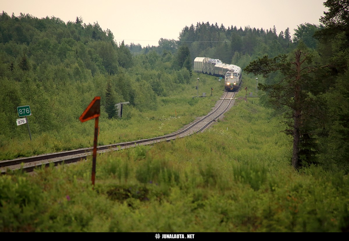 PYO263 @ Laivakangas (Tornio) 02.07.2016
Kolarin yöjunan kuvauspaikaksi valikoitui tuttu ja turvallinen Laivakankaan(?) soravaihteen suora. ...mikä sitten mahtaa virallisesti ollakaan, mutta päätin kutsua tätä paikkaa nyt tällä nimellä. Ratalinja on moottoritielle saakka jo hyvin pusikoitunut, mutta moottoritien jälkeen ratalinja on muuttunut hiekkapohjaiseksi tieksi, joka palvelee lähinnä lenkkeilijöitä. Toistaiseksi ei ole tullut käytyä nuuskimassa, löytyisikö soramontun alueelta mitään jäänteitä radasta. Yksi jäänne näkyy kuitenkin kuvassakin: sortumaisillaan oleva vaihdekoppi! 

Tämä yöjuna oli tarkoitus kuvata vielä toistamiseen Tornion ja Kolarin välillä, mutta valtava erikoiskuljetuskolonna lopetti kiireen ja katkaisi matkanteon tunniksi Korpikylän aseman kohdalla. Paluujuna oli sikäli erikoinen, että vetovastuu oli syystä tai toisesta edelleenkin vaalealla 2809:lla!
Avainsanat: PYO263 yöjuna Dr16_2809 Dr16_2811 20160702