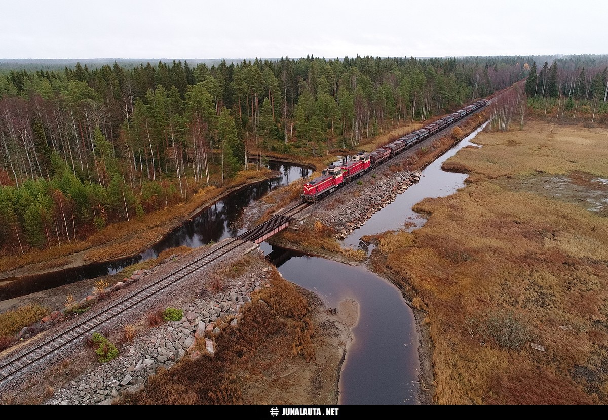 T5041 @ Kuonanjärvi (Haapajärvi-Pyhäsalmi) 17.10.2018
Pilvinen ja harmaa syyskeli ei ollut kaikkein ihanteellisin sää dronettaa Kuonanjärven penkereellä, kun sekä vesi että taivas olivat harmaita ja veturit pahimmassa tapauksessa muun kuin punaisen tai sinisen värisiä... Keli oli kuitenkin täydellinen lennellä penkereen itäpään mielenkiintoisissa maisemissa vedenpinnan ollessa vieläpä normaalia alempana! :) 
Avainsanat: T5041 Dv12_2631 Dv12_2731 rikastejuna pyhäkumpulaine dronekuva teräslevysilta 20181017